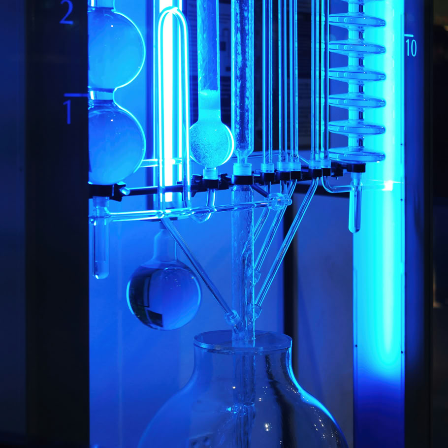Tecnico in giacca blu che utilizza un trapano elettrico in un ambiente interno per la manutenzione.